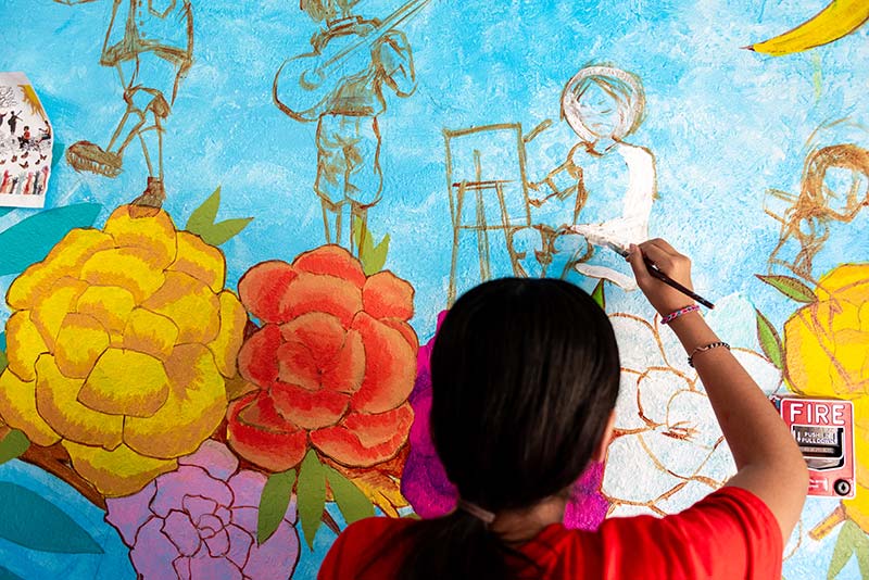 child painting mural on the wall
